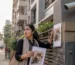 A worried pet owner searching for a missing cat near an apartment building in Bangladesh with a CCTV camera visible